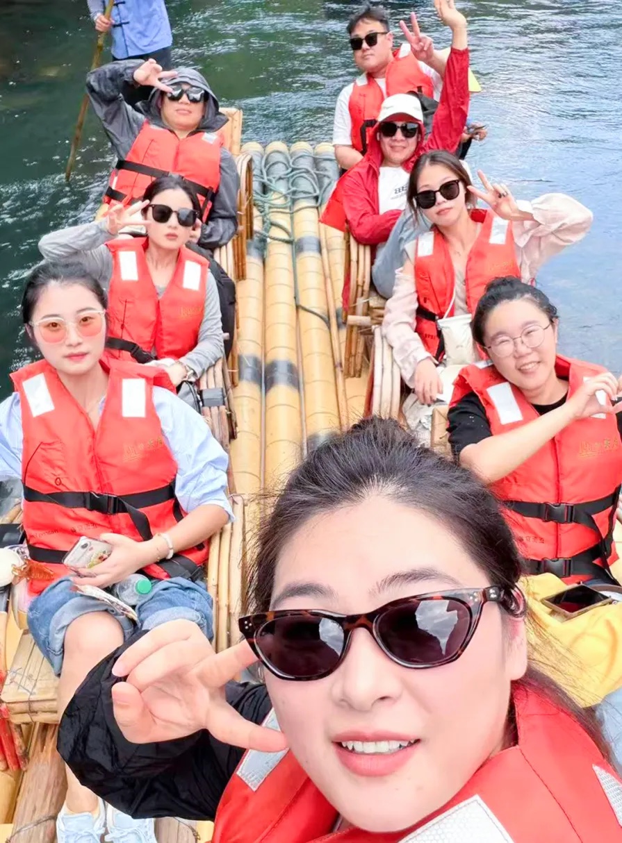 Chuanhe colleagues wearing life jackets on a bamboo raft on the Jiuqu River
